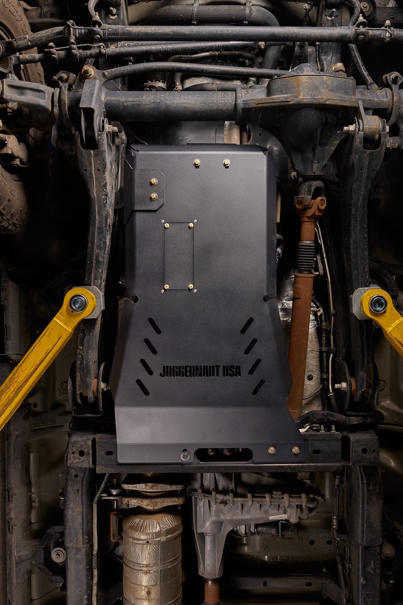 Ford Super Duty on the lift at Juggernaut USA with aluminum underbody armor installed